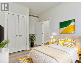 A bedroom with a bed, two nightstands, and a plant.