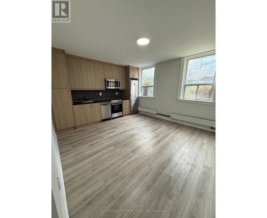 A spacious kitchen with wooden cabinets and a microwave.
