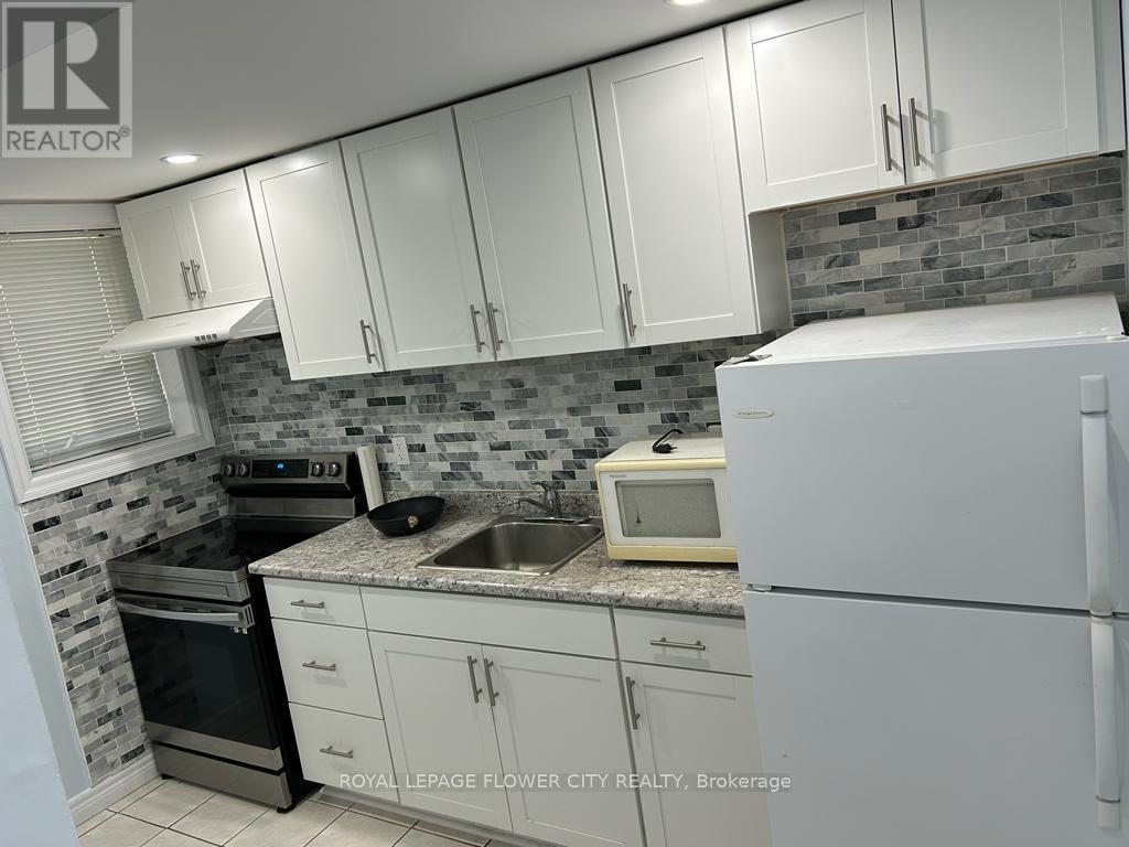 A kitchen with white cabinets and a white refrigerator.