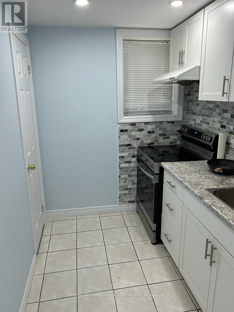 A kitchen with a tile floor and white cabinets.