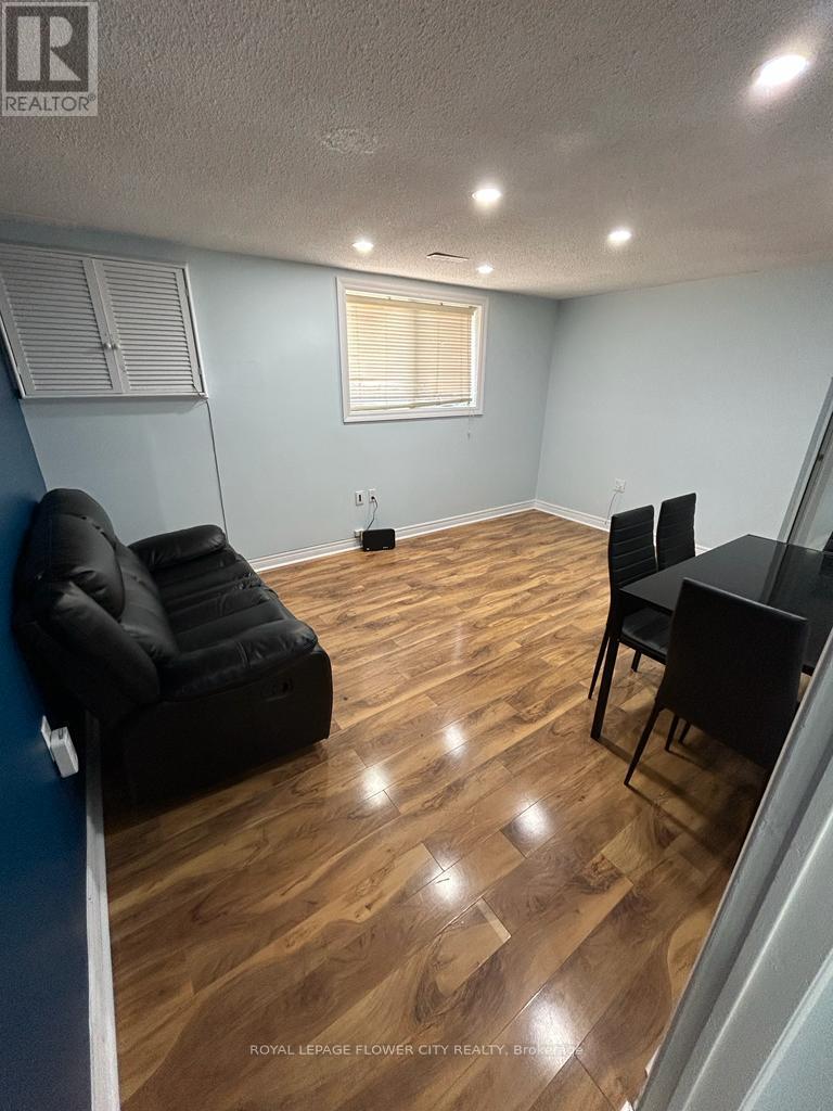 A living room with a black couch and a black chair.