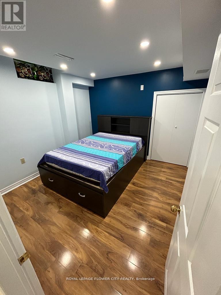 A bedroom with a bed, drawers, and a TV on the wall.