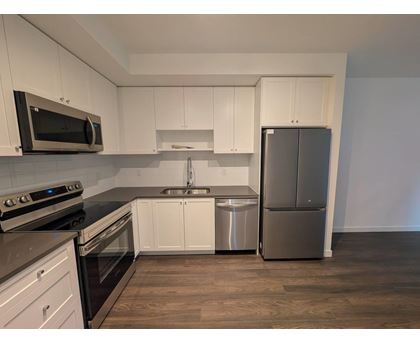 A kitchen with white cabinets and stainless steel appliances.
