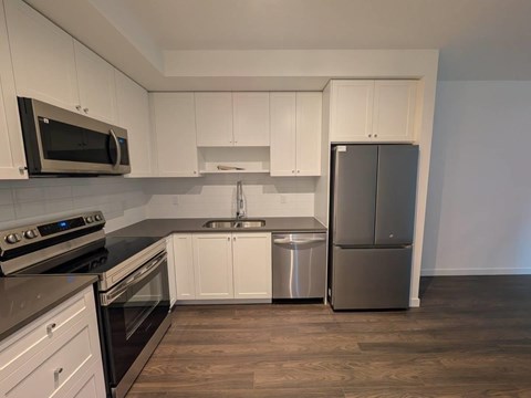 A kitchen with white cabinets and stainless steel appliances.