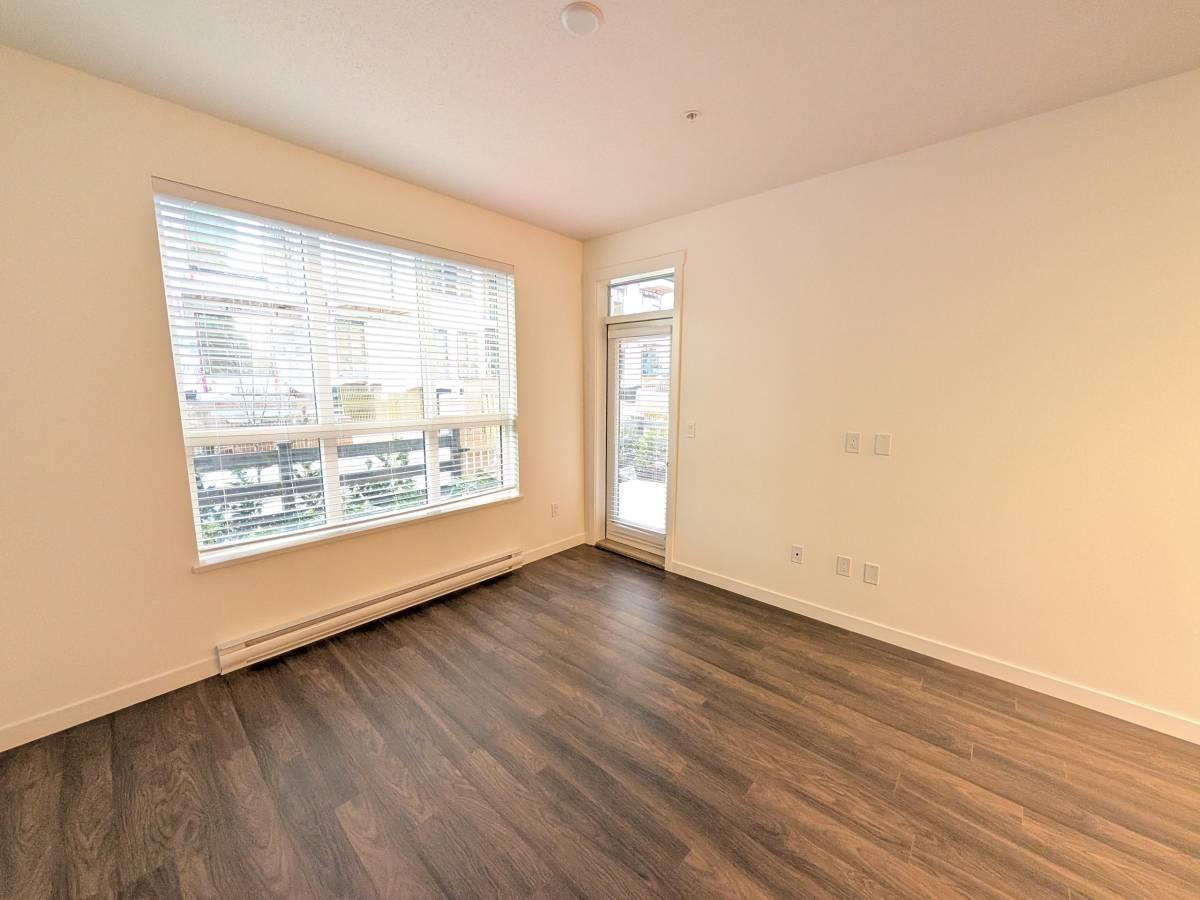 A room with a window and a door is empty and waiting to be furnished.