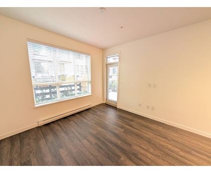 A room with a window and a door is empty and waiting to be furnished.