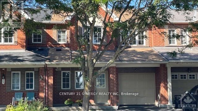 A red brick building with a tree in front and a sign that says Century 21 Synergy Realty Inc. Brokerage.