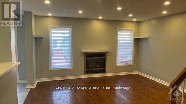 A well-lit room with a fireplace and a window with blinds.