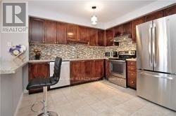 A kitchen with wooden cabinets and a stone backsplash.