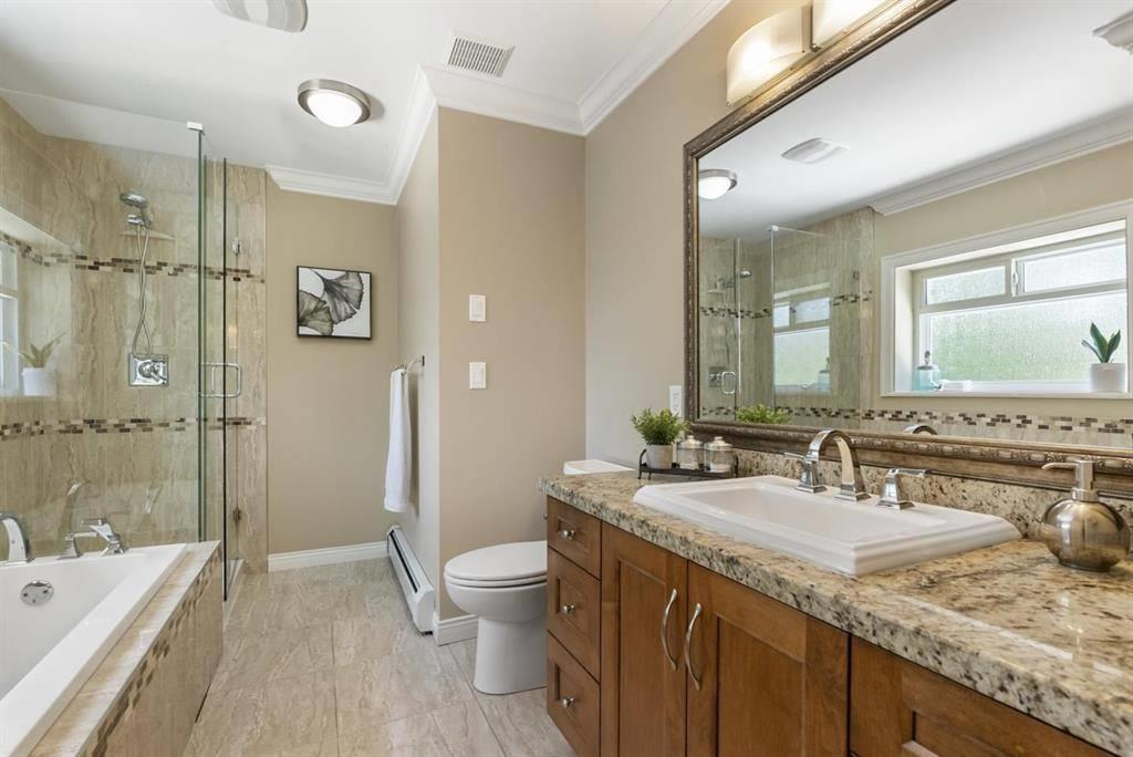 A bathroom with a marble countertop and a large mirror.