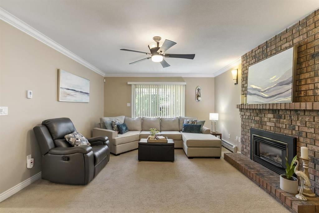 A living room with a fireplace and a ceiling fan.