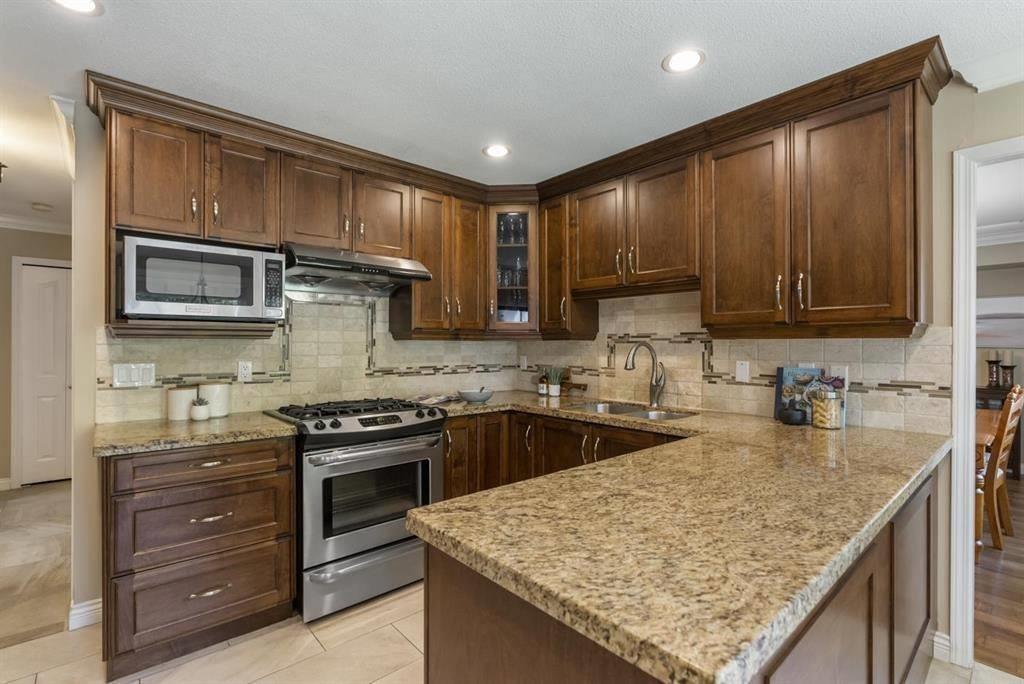 A kitchen with brown cabinets and granite countertops.
