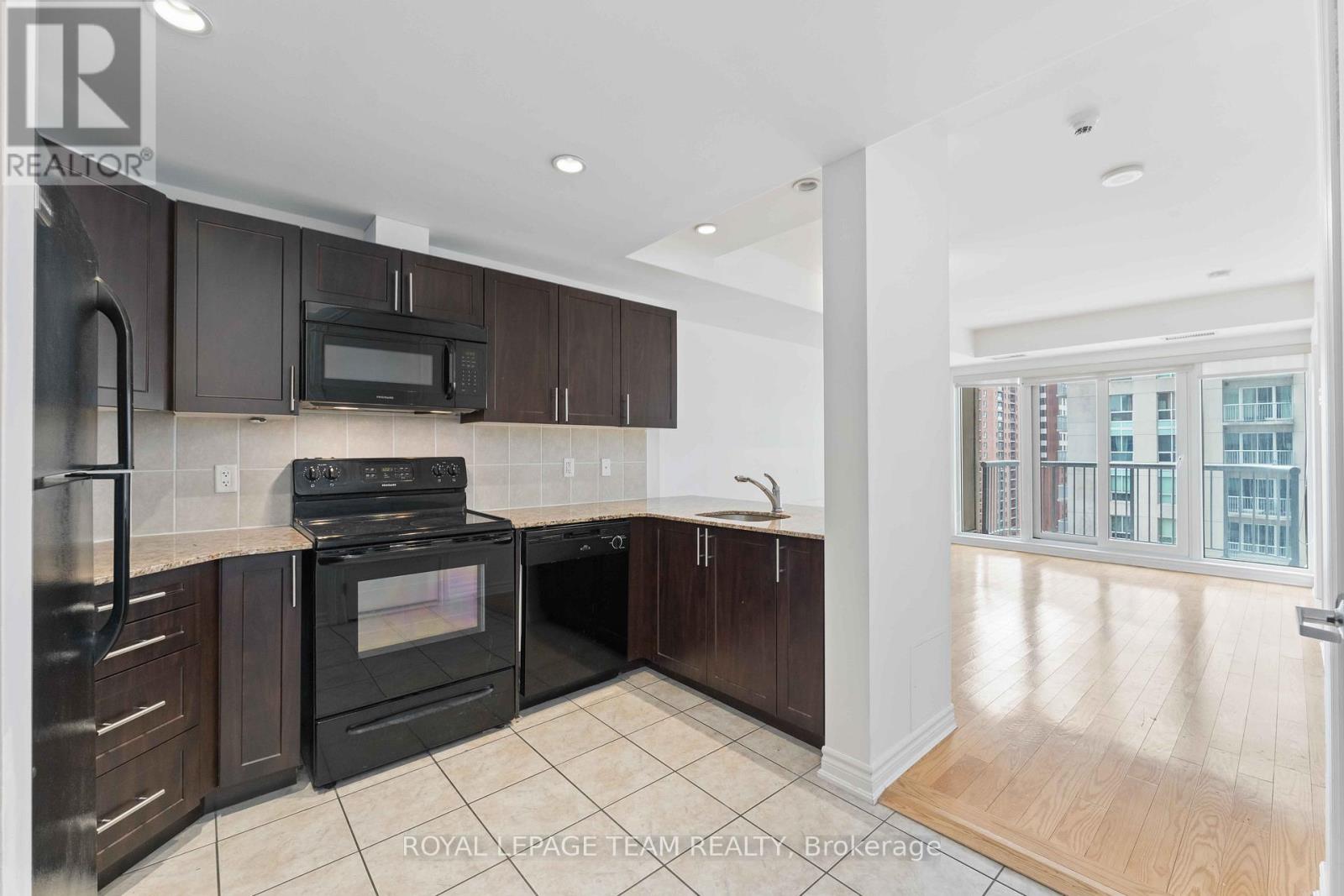 A modern kitchen with dark brown cabinets and a black stove top oven.