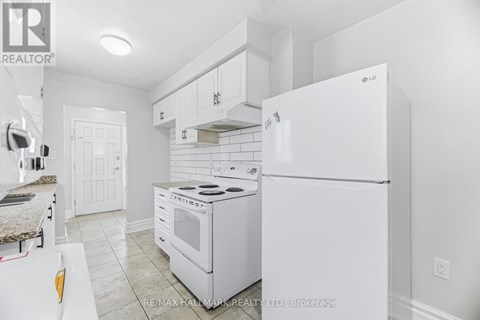 A white kitchen with a stove and refrigerator.