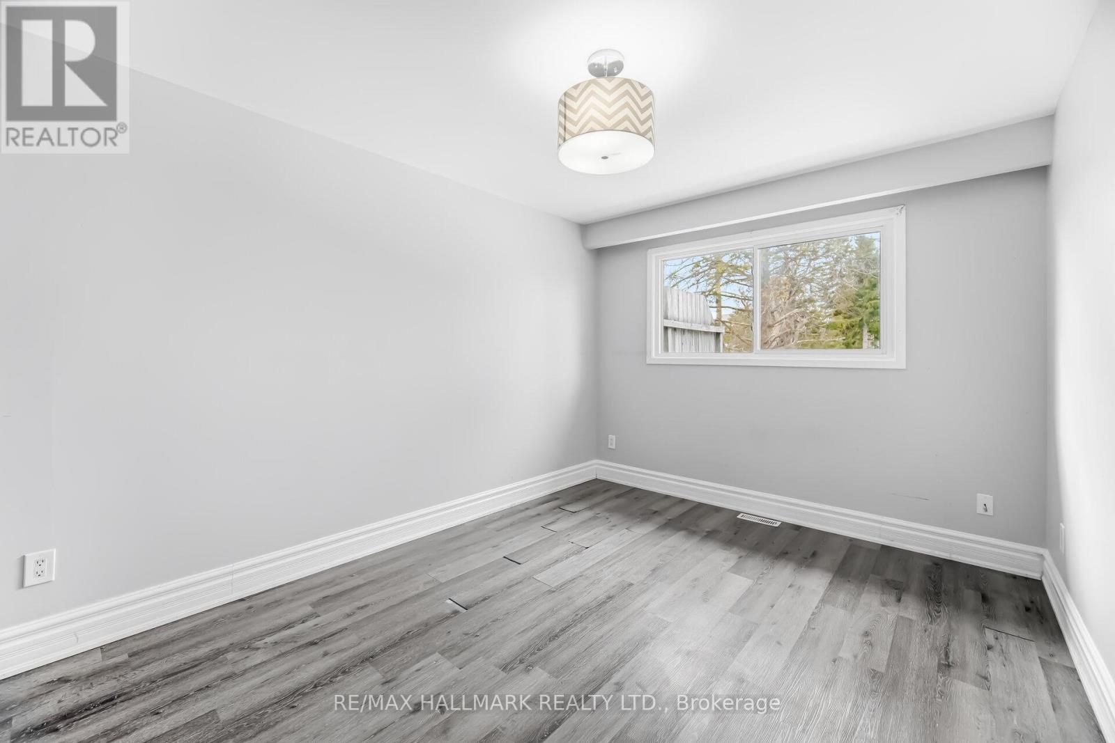 A room with a window showing trees outside.