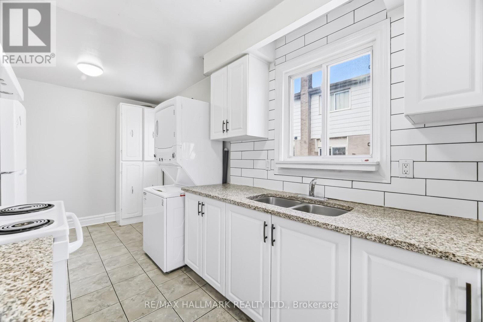 A kitchen with white cabinets and a granite countertop.