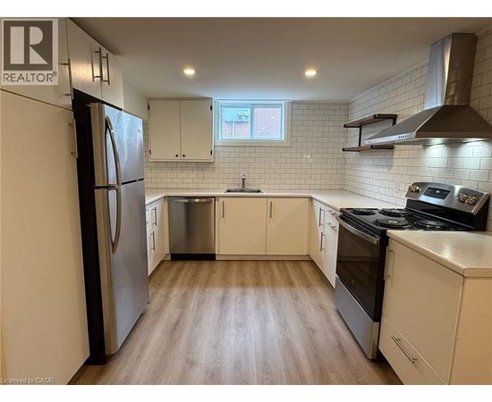 A kitchen with white cabinets and a stainless steel refrigerator.