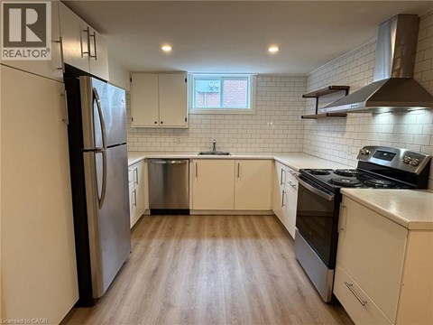 A kitchen with white cabinets and a stainless steel refrigerator.