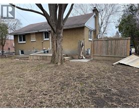 A house with a brown fence and a tree in front.