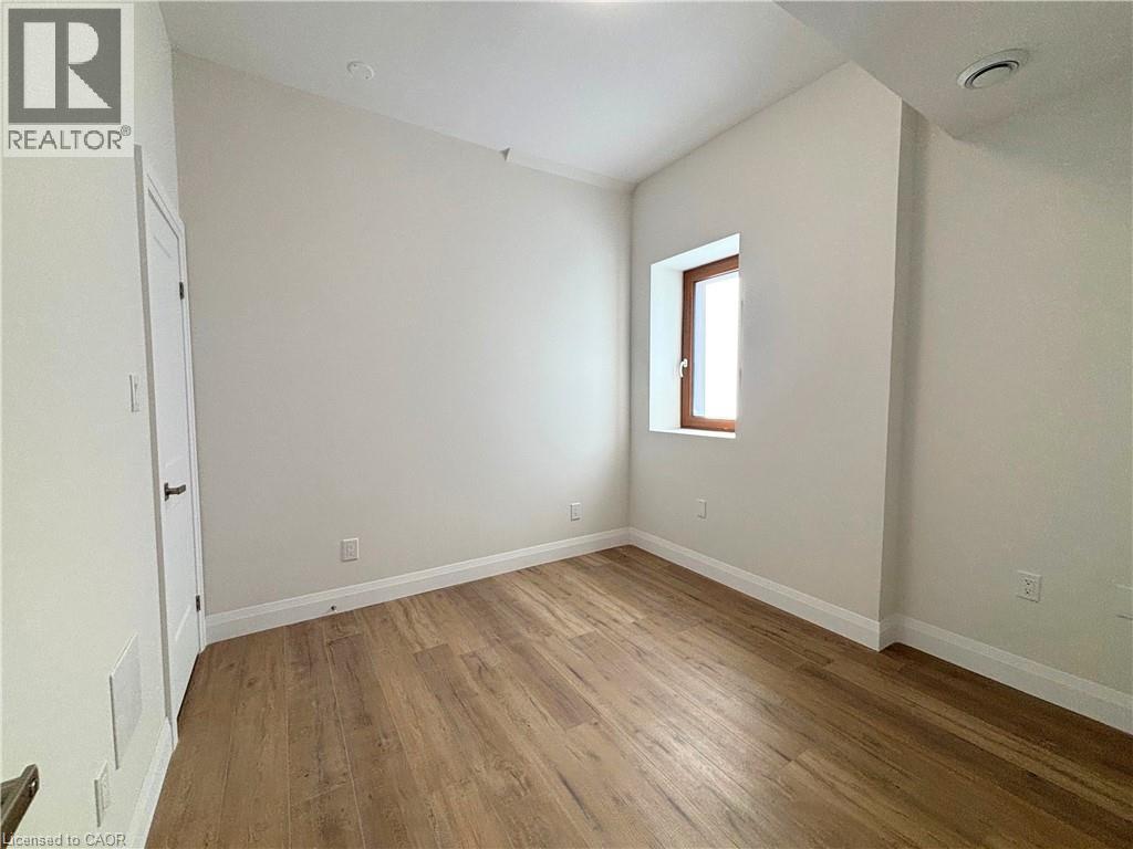 A room with wooden flooring and a window.