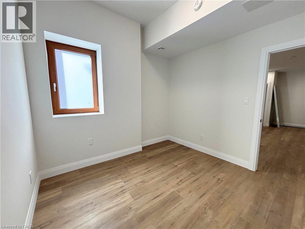A room with wooden flooring and a window.