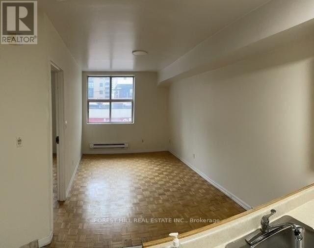 A room with a window and a wooden floor.