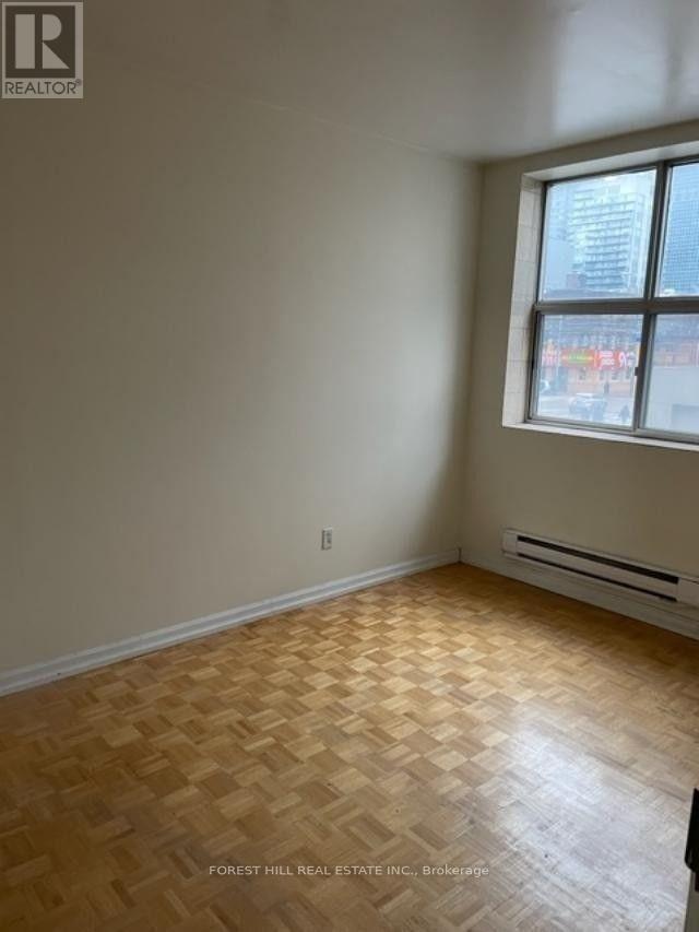 A room with wooden flooring and a window.