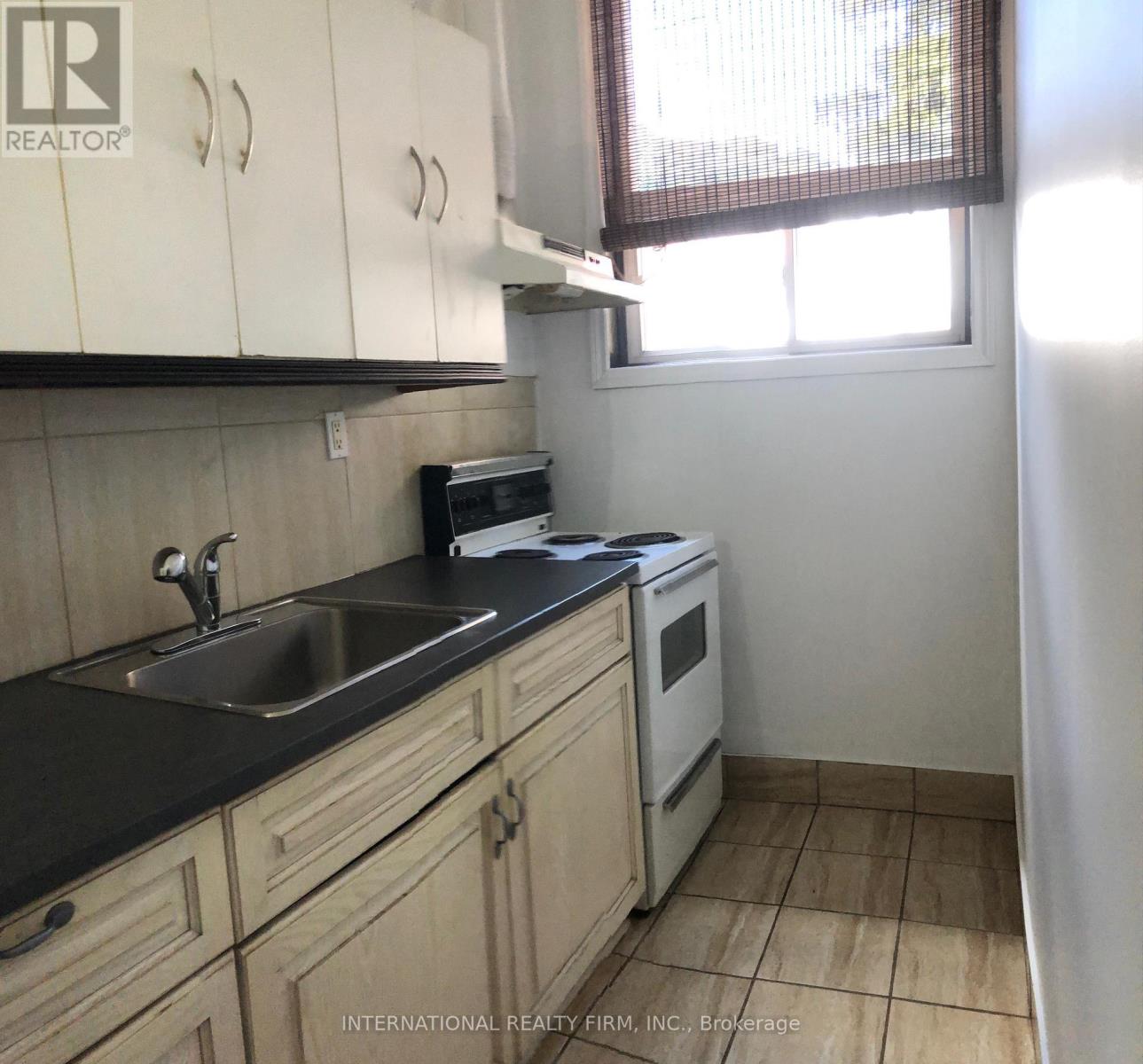 A kitchen with a sink, stove, and oven.
