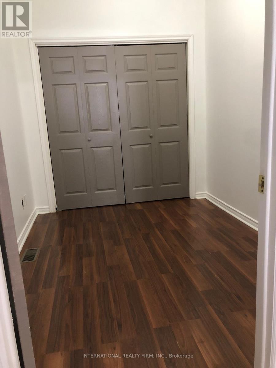 A wood floor in a room with a white door.