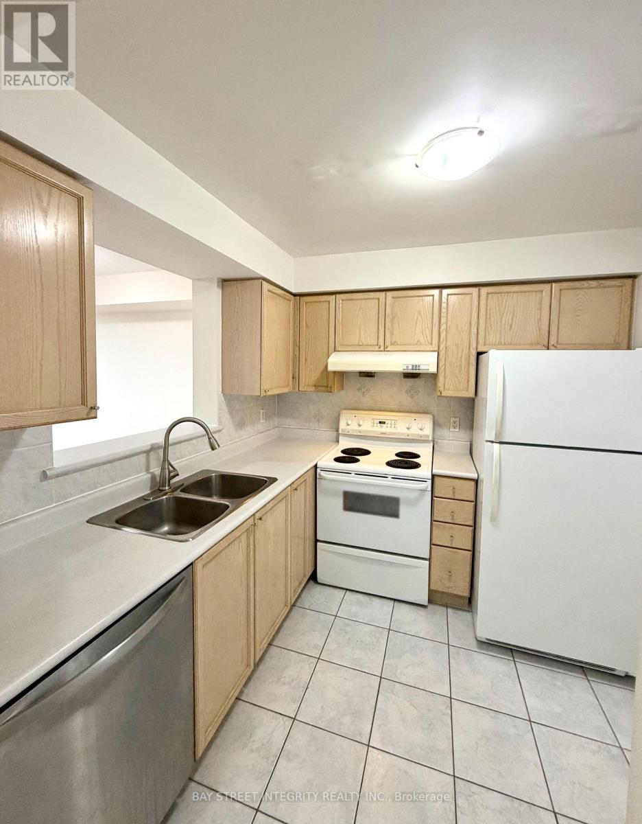 A kitchen with white appliances and wooden cabinets.