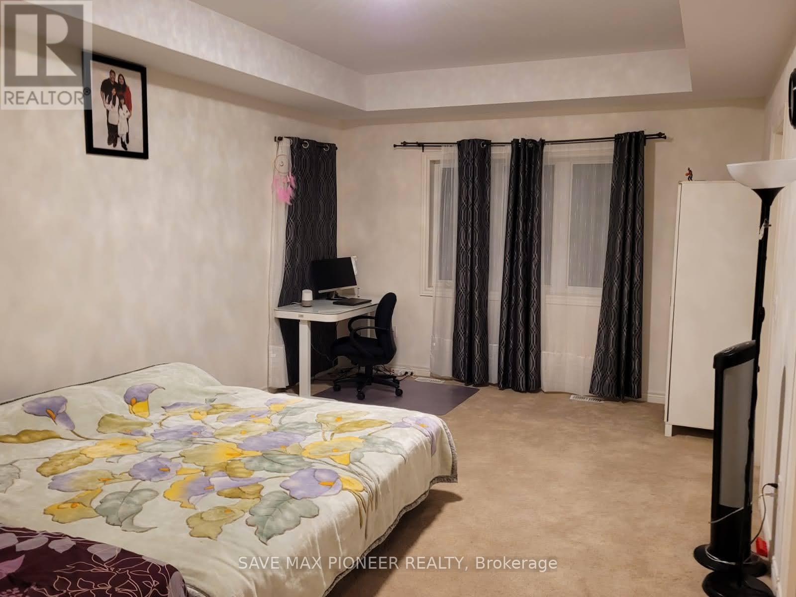 A bedroom with a bed, desk, and chair.