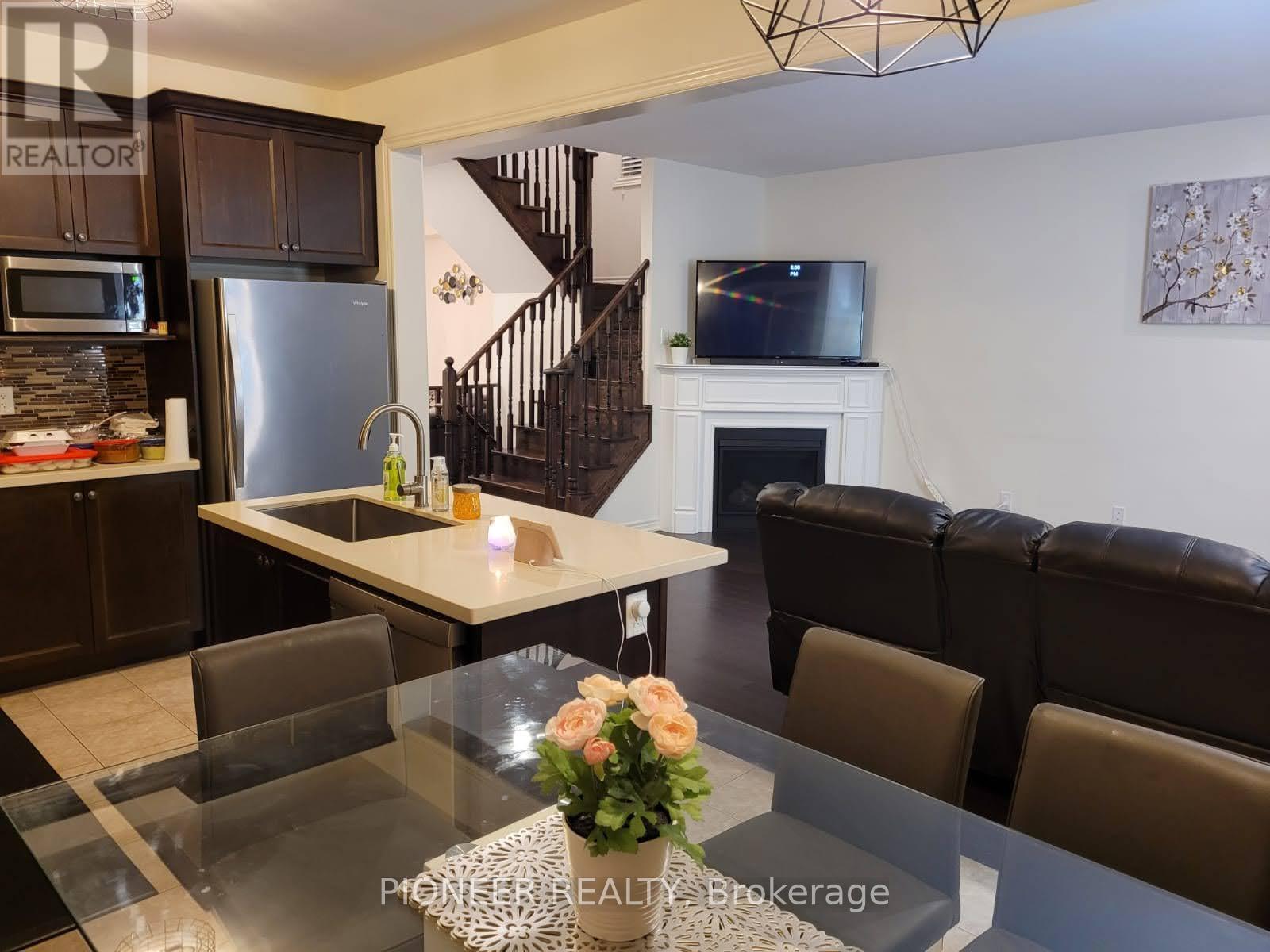 A modern kitchen with a glass table and a leather couch.