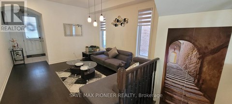 A living room with a couch, coffee table, and a painting of a staircase.