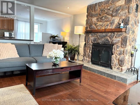 A living room with a stone fireplace and a coffee table with flowers on it.