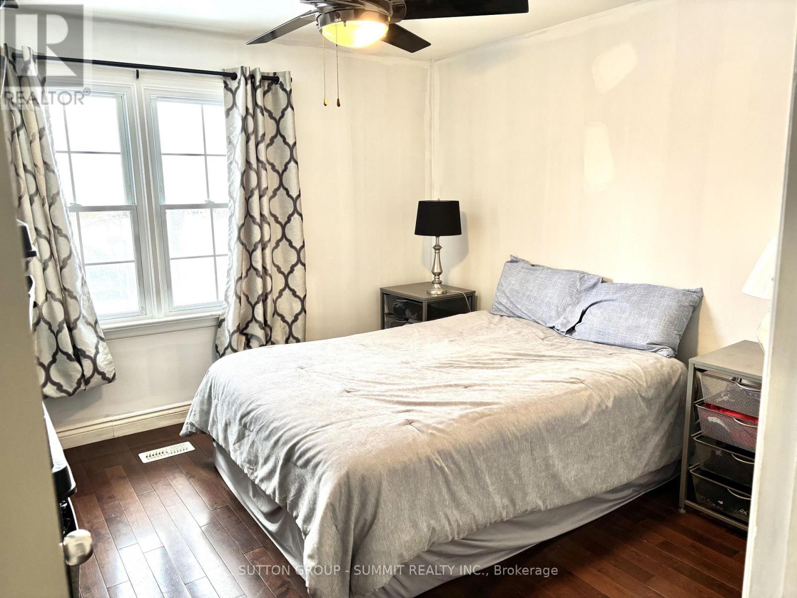 A bedroom with a bed, nightstand, and window.