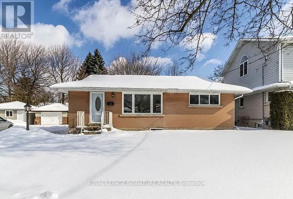 A house with a brown siding and a white roof is surrounded by snow.