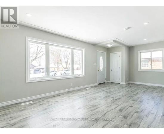A spacious room with grey flooring and white walls.
