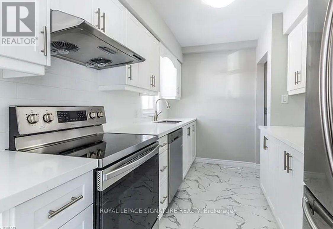 A modern kitchen with white cabinets and a black stove top oven.