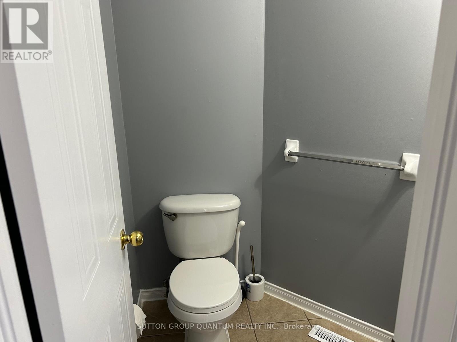 A white toilet in a small bathroom with a white door.