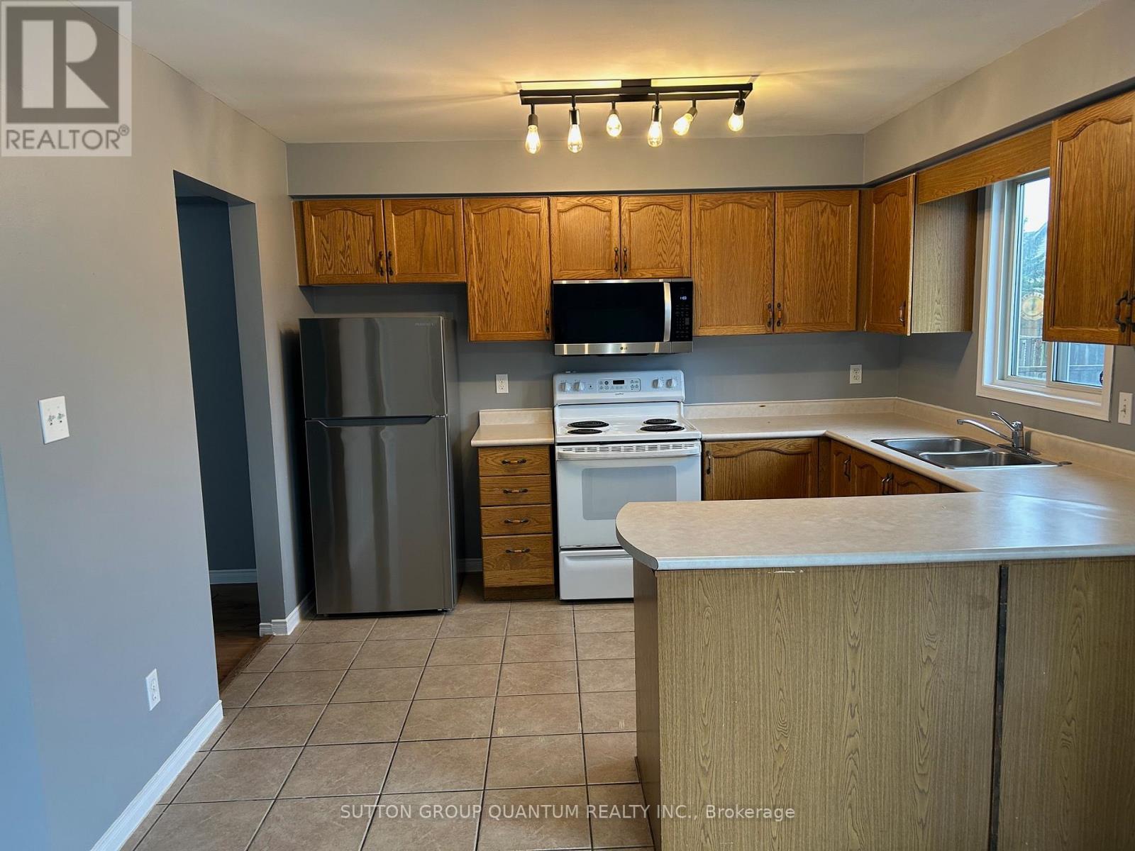 A kitchen with a refrigerator, stove, and microwave.