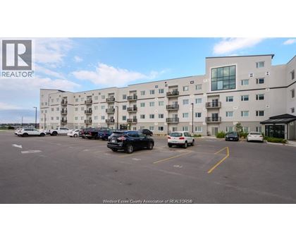 A parking lot in front of a large white building with the logo REALTOR on it.