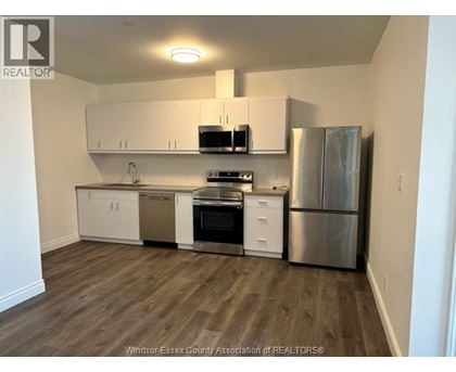 A kitchen with white cabinets and stainless steel appliances.