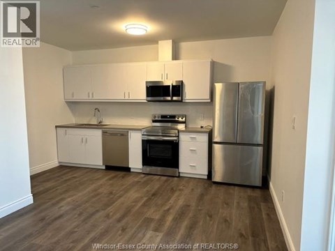 A kitchen with white cabinets and stainless steel appliances.