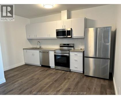 A kitchen with white cabinets and stainless steel appliances.
