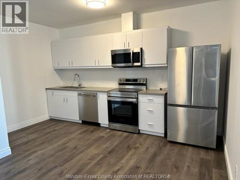 A kitchen with white cabinets and stainless steel appliances.