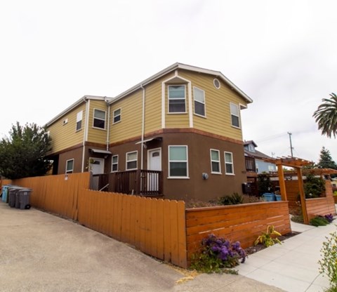 A two-story house with a brown and yellow exterior.
