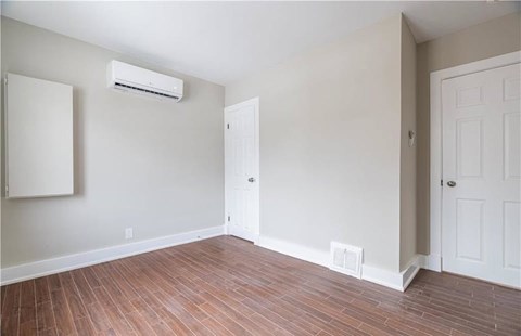 A room with a white door and a white wall with a window.
