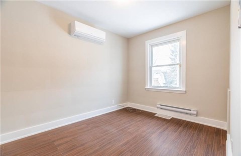 A room with a window and a wall-mounted air conditioner.