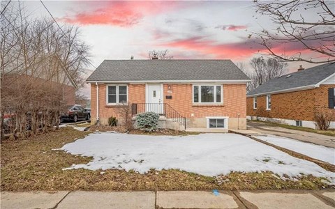 A house with a snow-covered front yard.