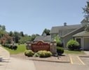 A red sign is in front of a house.